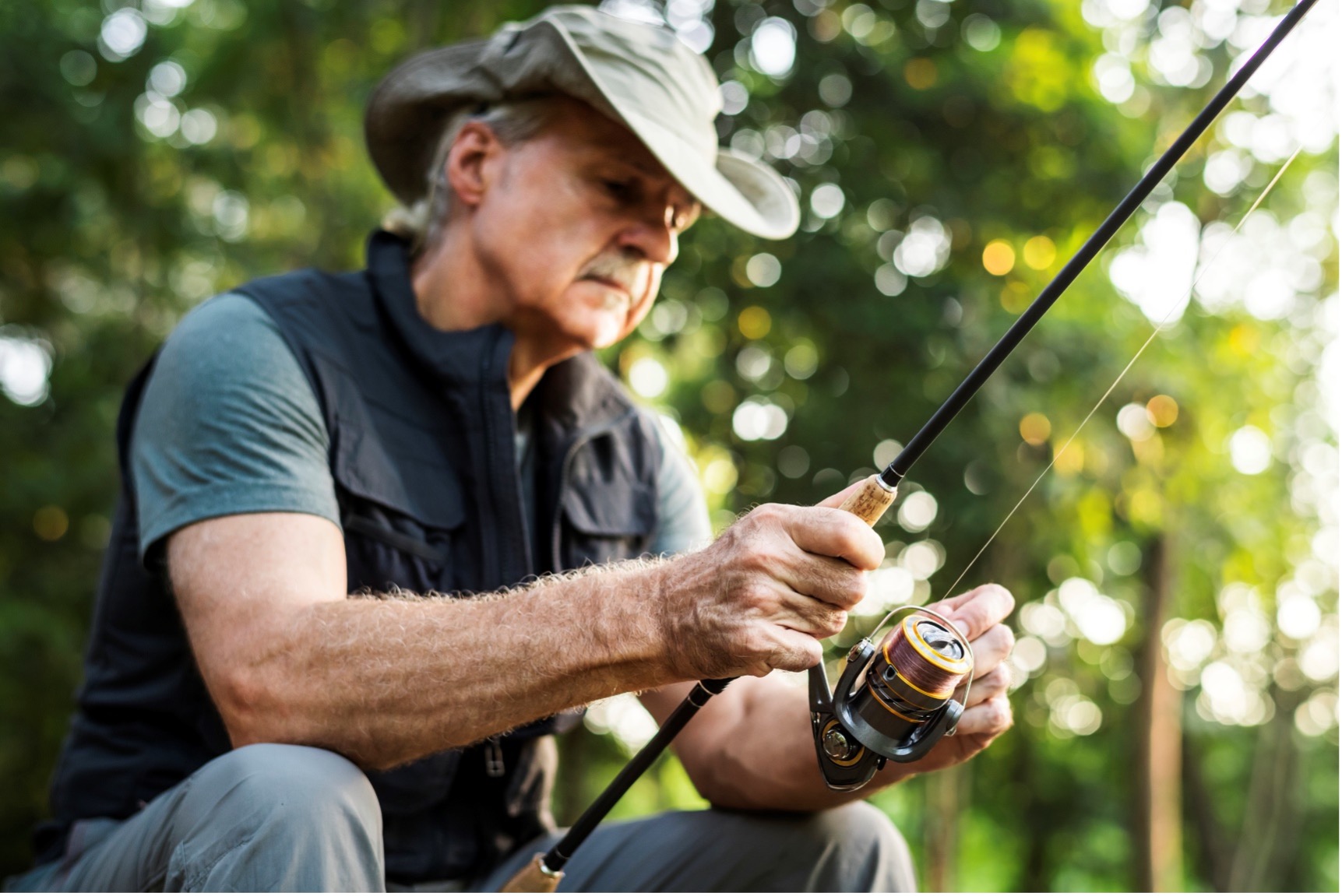 Man in hat fishing.