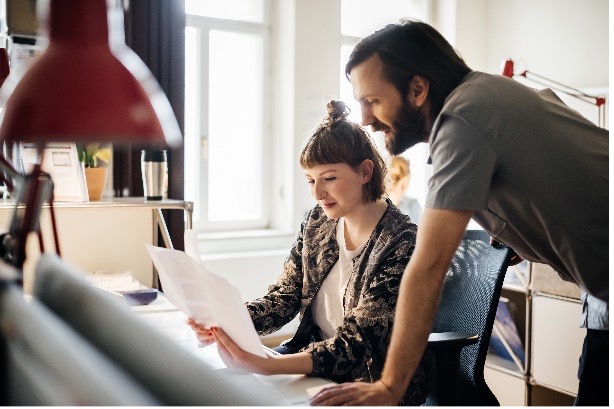 Man teaching woman how to play piano.